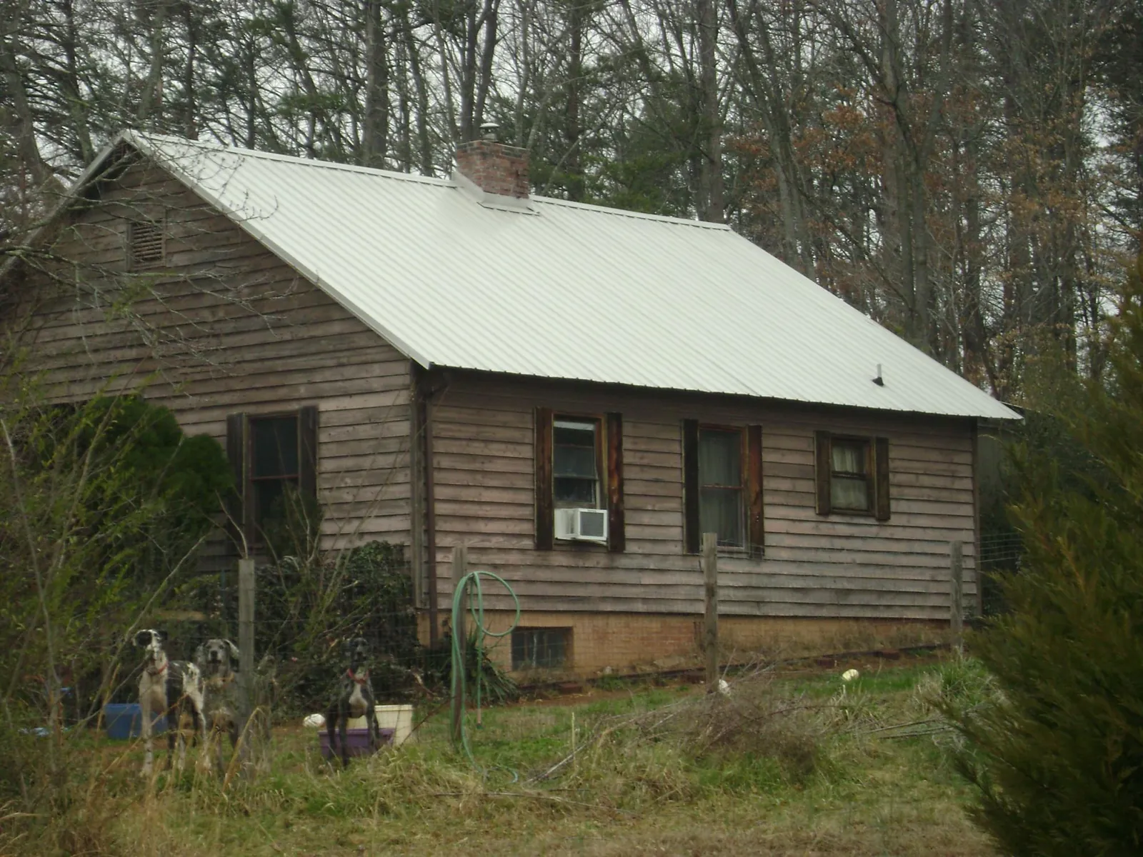 White metal roof on an old wood sided farmhouse, from a Metal Roof Installation job in Memphis